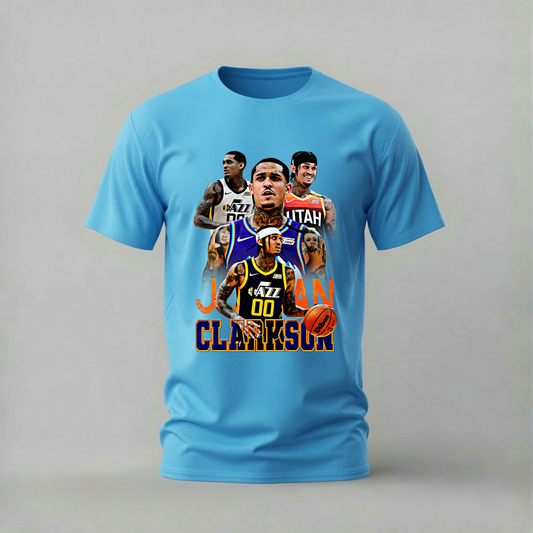 A light blue short-sleeve t-shirt with a graphic collage of basketball player Jordan Clarkson and the text 'JORDAN CLARKSON' on the front, displayed against a neutral gray background.