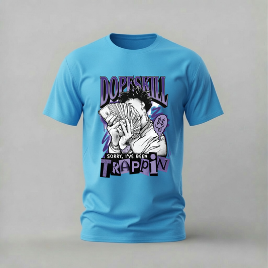 A light blue short-sleeve t-shirt with a graphic print on the front, featuring the text 'DopeSkill' and 'Sorry, I've Been Trappin' with an illustration of a person holding cards.