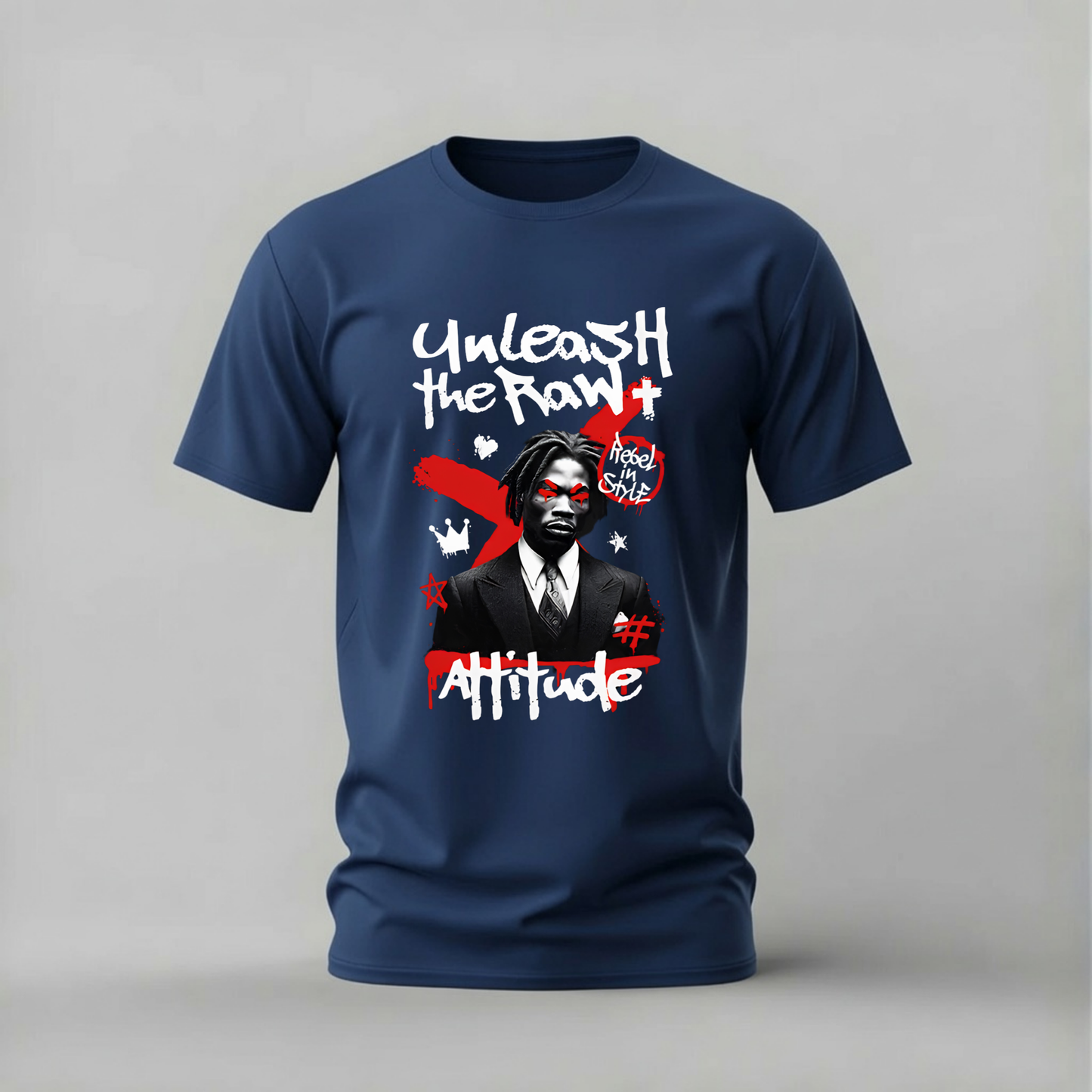 A navy blue short-sleeve t-shirt with a graphic print on the front, featuring the text 'Unleash the RAW+ Attitude' and a stylized portrait of a man, shown against a neutral gray background.