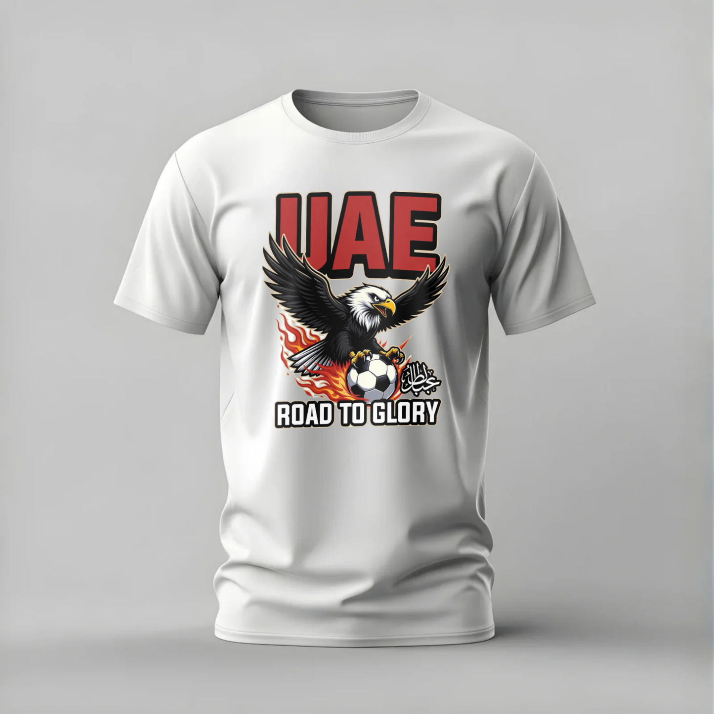White t-shirt with UAE eagle and soccer ball design on a gray background